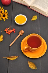 Autumn still life cup of tea, honey and book on the table