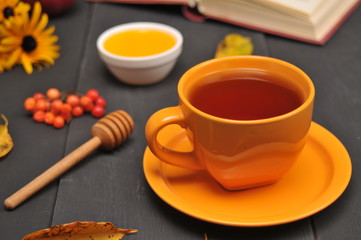 Autumn still life cup of tea, honey and book on the table