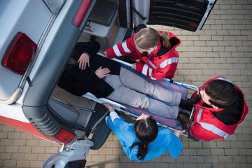 top view of paramedic team moving man on ambulance stretcher into car © LIGHTFIELD STUDIOS