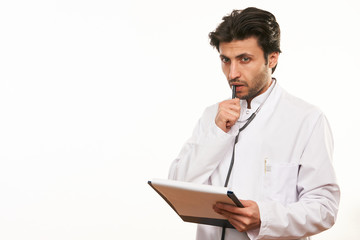 Young male doctor holding clipboard