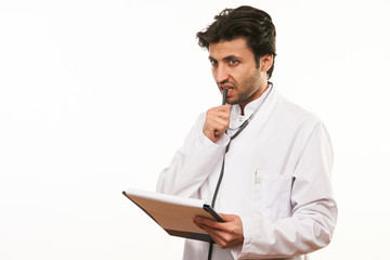 Young male doctor holding clipboard