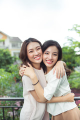 Naklejka premium Happy young women friends well-dressed smiling while standing together