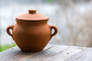 Empty clay pot on a wooden table in garden