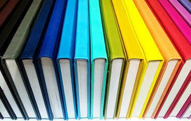 Books. A lot of books with bright covers in one pile isolated on white background. Design element, paper and leather texture. Colorful books on the shelf, close up