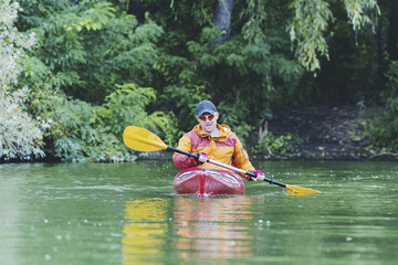 Canoeing. A man is rowing along the river.