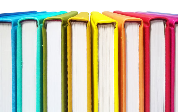 Books. A lot of books with bright covers in one pile isolated on white background. Design element, paper and leather texture. Colorful books on the shelf, close up