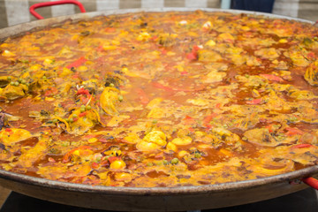  The cooking process of  paella in a huge frying pan.