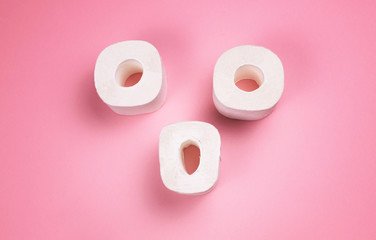 A few rolls of toilet paper on a bright colored background.