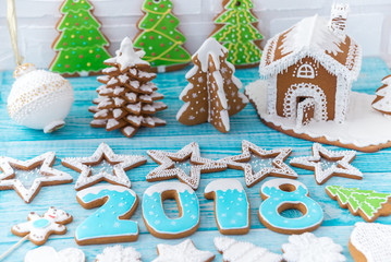 Gingerbread cookies, snowflakes hanging with ribbon over a blue wood background. Free space copyspace for your text. 2018 New Year