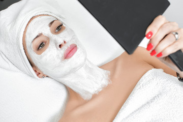 woman getting facial mask in spa