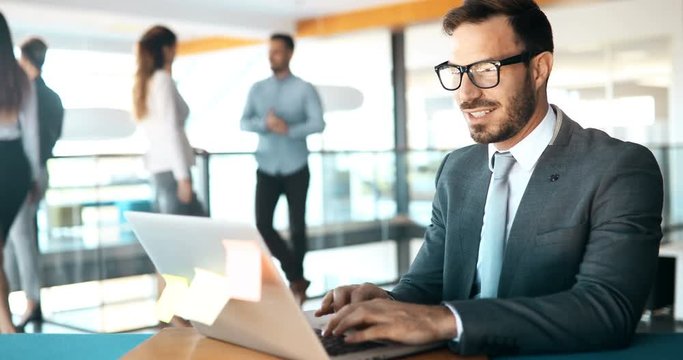 Young handsome architect working on laptop in office