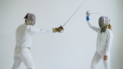 Two fencers have fencing training on white background