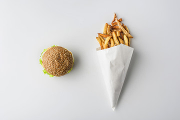 top view of hamburger and french fries in paper cone, isolated on white