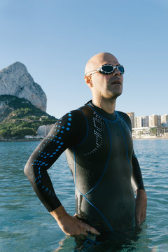 Diver in wet suit standing on beach