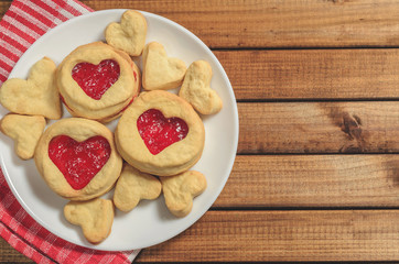 Homemade cookies in heart-shaped gifts and red paper hearts, greetings on Valentine's day, top view