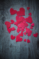 Background for Valentine's Day. Hearts of handmade work on a wooden table. Top view