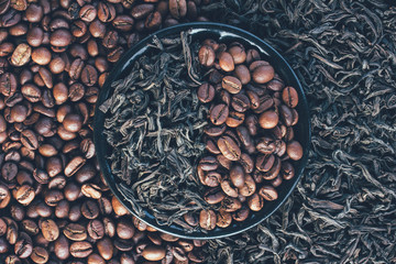 roasted coffee beans and dry leaves of black tea, top view closeup
