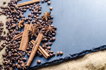 grains of coffee with cinnamon on sackcloth