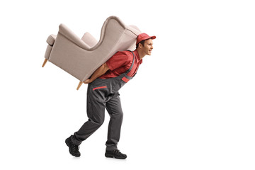 Mover walking and carrying an armchair on his back