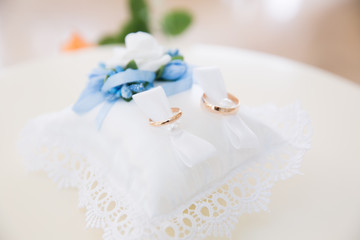 Wedding boutonniere on suit of groom and bride’s hand 