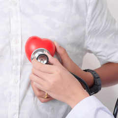 Doctor checking the red heart with ecg line and stethoscope. Isolated on white background. Studio lighting. Concept for healthy