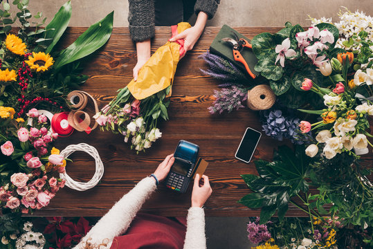cropped image of customer paying with credit card for bouquet