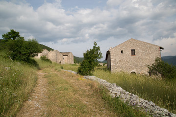 Fototapeta na wymiar Sentiero, Antiche case restaurate in un villaggio di montagna abbandonato, Centro Italia 