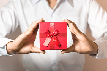 Business man hold red gift box in hands.