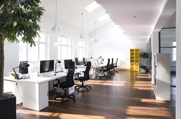 Desks with PCs in bright and modern open space office