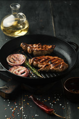 Grilled steak of pork with spices, rosemary and chili pepper in a frying pan