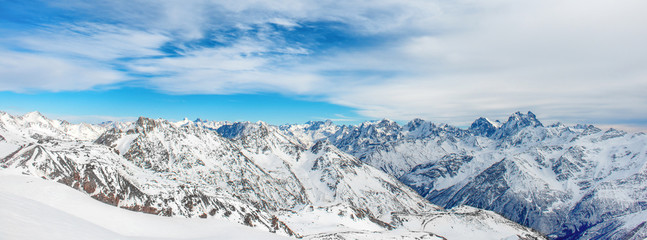 Obraz premium Mountains in snow. Panorama of winter landscape with peaks and blue sky