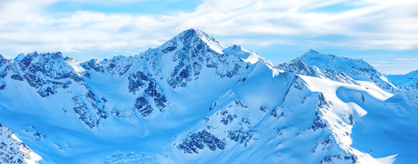 Fototapeta premium Góry w śniegu. Panorama zima krajobraz z szczytami i niebieskim niebem