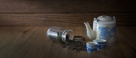Chinese tea with old teapot set and dried tea leaf in bottle and out bottle on wooden background ...