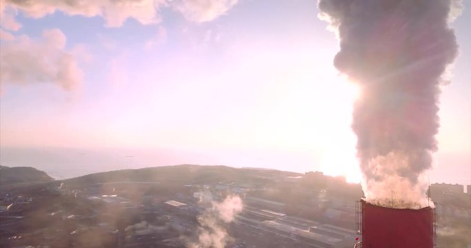 Great aerial panoramic view of Central Heating and Power Plant chimneys with steam rising from them. Vladivostok is on the background, Russia. Sunrise