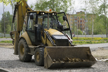 farm tractor with bucket down and hay and straw inside