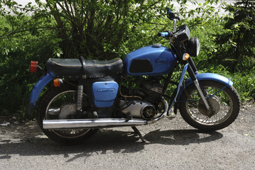 Naklejka premium Vintage motorcycle standing in in the rays of sunlight. Side view