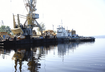 Fototapeta premium Monumental cranes at sunset.a ship in port