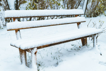 bench in the park with snow