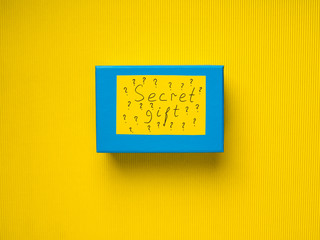 Closed Blue box with concept Secret gift card on yellow background
