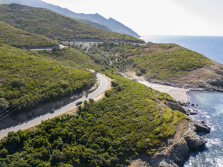 Vista aerea della costa della Corsica, strade serpeggianti e calette con mare cristallino. Penisola...