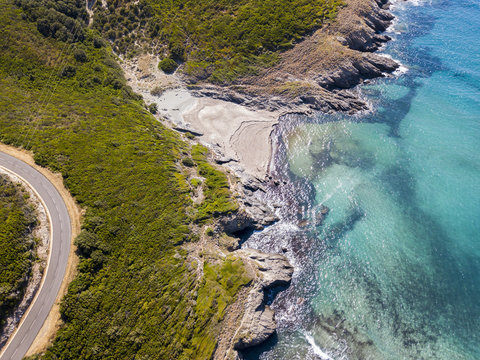 Vista aerea della costa della Corsica, strade serpeggianti e calette con mare cristallino. Penisola di Cap Corse, Corsica. Tratto di costa. Anse d'Aliso. Golfo d&rsquo;Aliso. Francia
