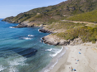 Vista aerea della costa della Corsica, strade serpeggianti e calette con mare cristallino. Penisola...