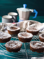 Chocolate chokecherry muffins with icing sugar. Winter christmas sweet food treat on dark green background