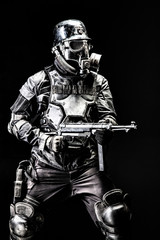 Futuristic  soldier gas mask and steel helmet with schmeisser handgun black background studio shot
