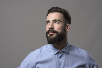 Fototapeta premium Confident young handsome stylish business man looking up at copyspace against gray studio background. Idea concept. 