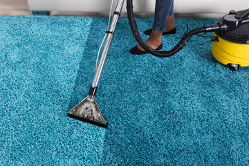 Person Using Vacuum Cleaner For Cleaning Carpet