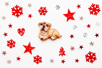 Christmas holiday background with decorations and New Year 2018 symbol - dog. Red and silver stars, felt snowflakes and star confetti. Flat lay, top view on white background.