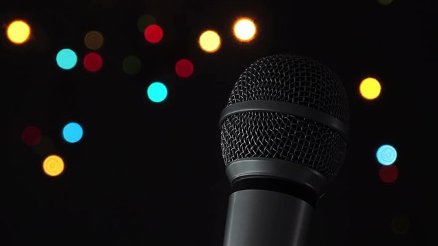 Audio microphone in karaoke bar with festive bokeh light background