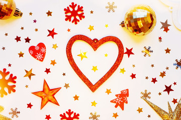 Christmas and New Year holiday background with decorations and light bulbs. Red and golden hearts, shiny balls, felt snowflakes and star confetti. Flat lay, top view.