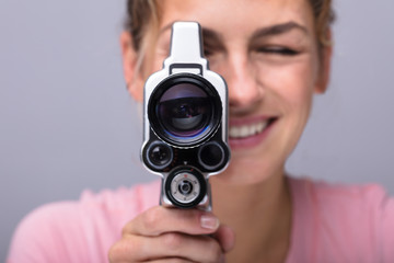 Woman Looking Through Lens Of Retro Camera